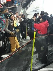 One athlete, taking pictures of another athlete, with some excited fans. Photo: Judy Berna