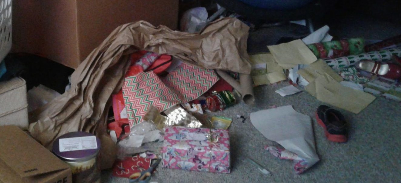 Floor cluttered with boxes, wrapping paper and supplies, packing material, and more