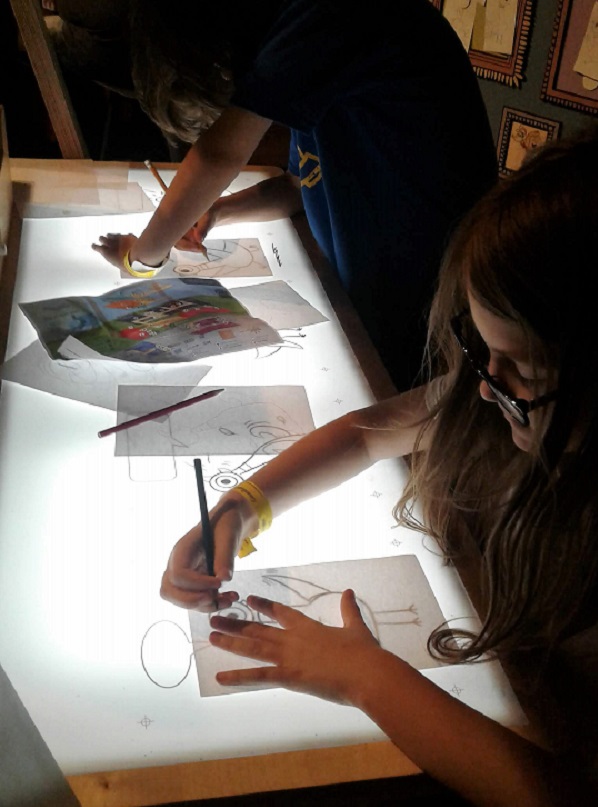 Two children tracing The Pigeon off a backlit light table