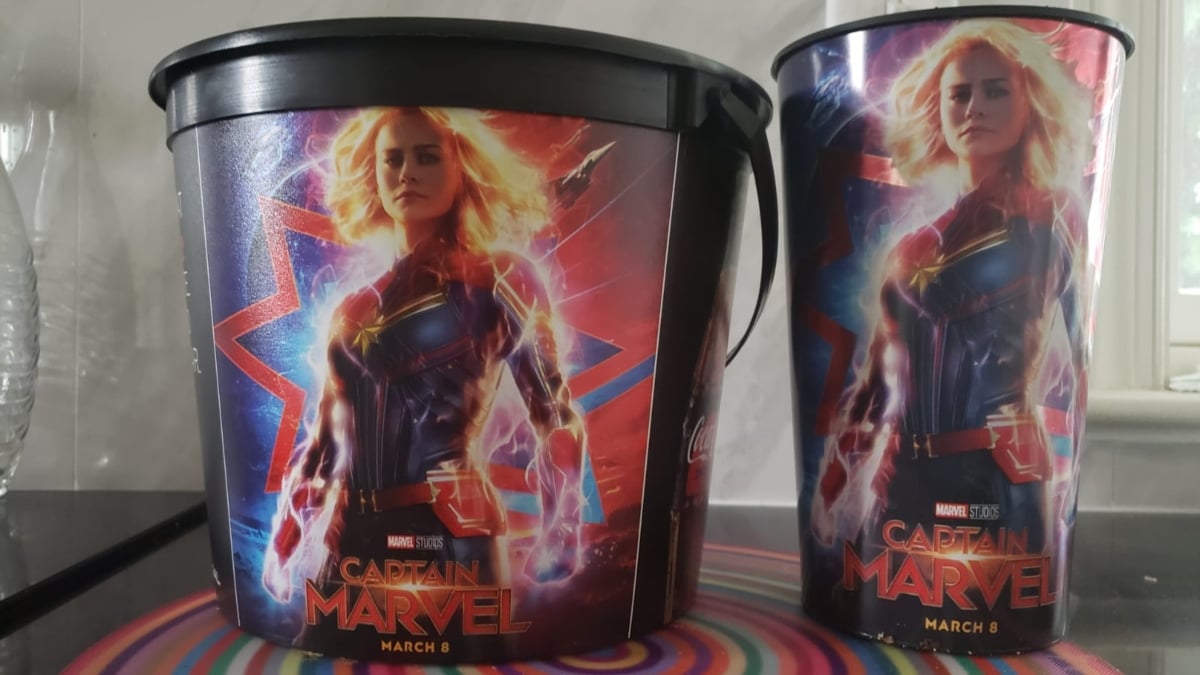 Captain Marvel movie images on a popcorn bucket and soda cup
